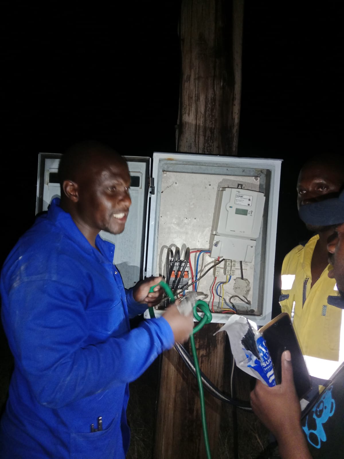 Technicians testing an open electrical panel on site