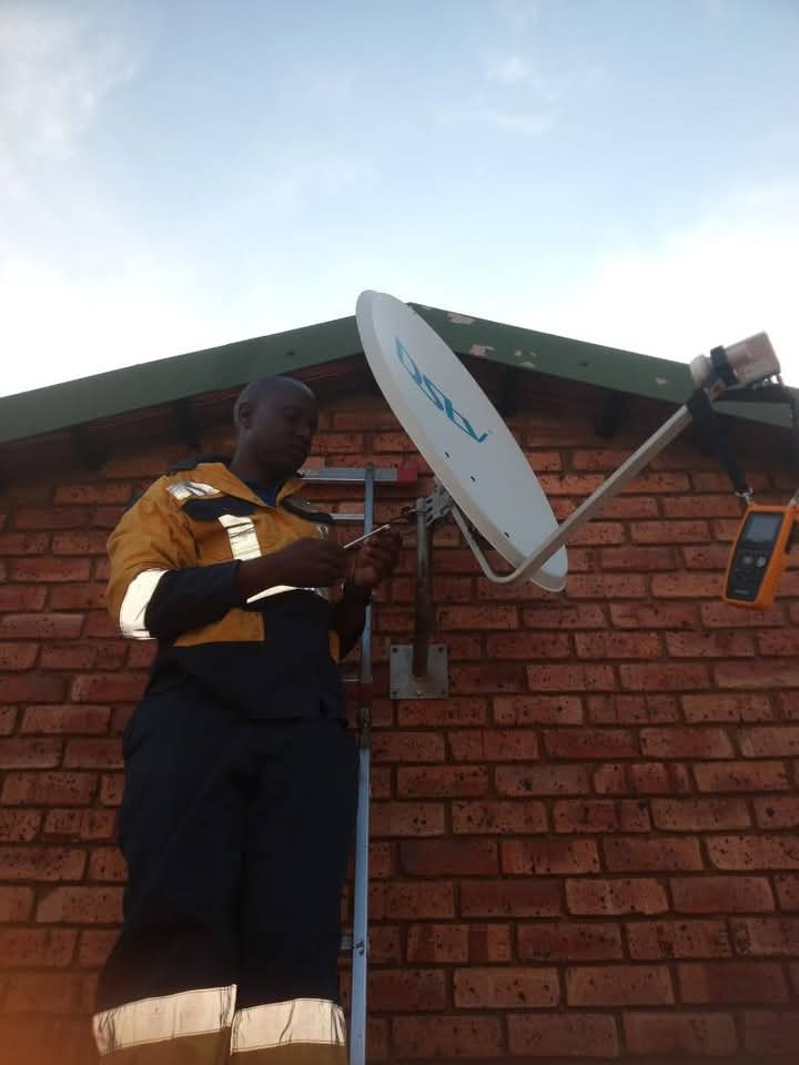 Technician adjusting exterior satellite or communication equipment