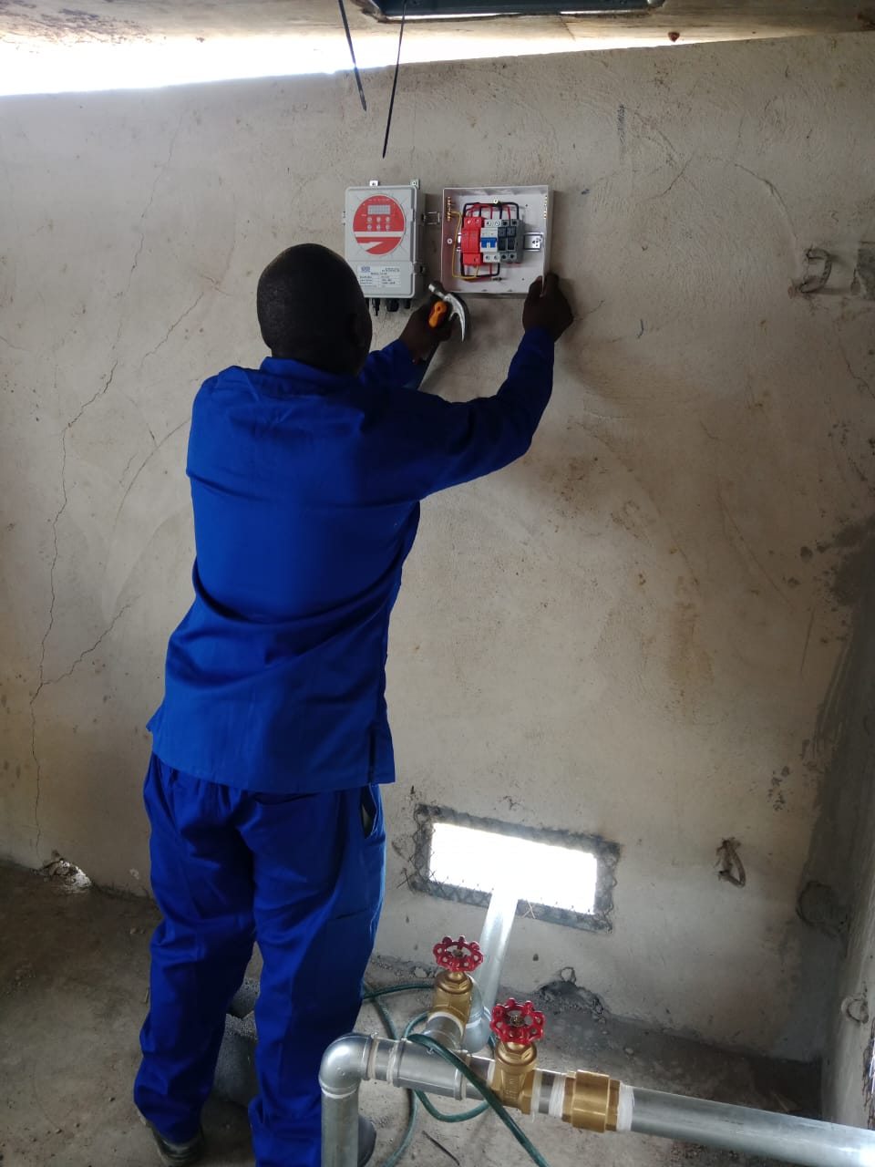Technician installing wall-mounted electrical components