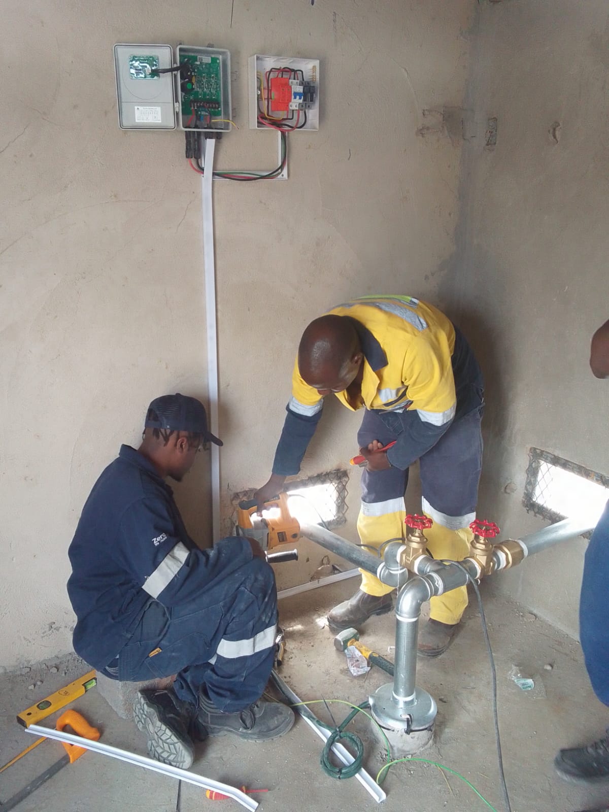 Technicians troubleshooting electrical equipment indoors