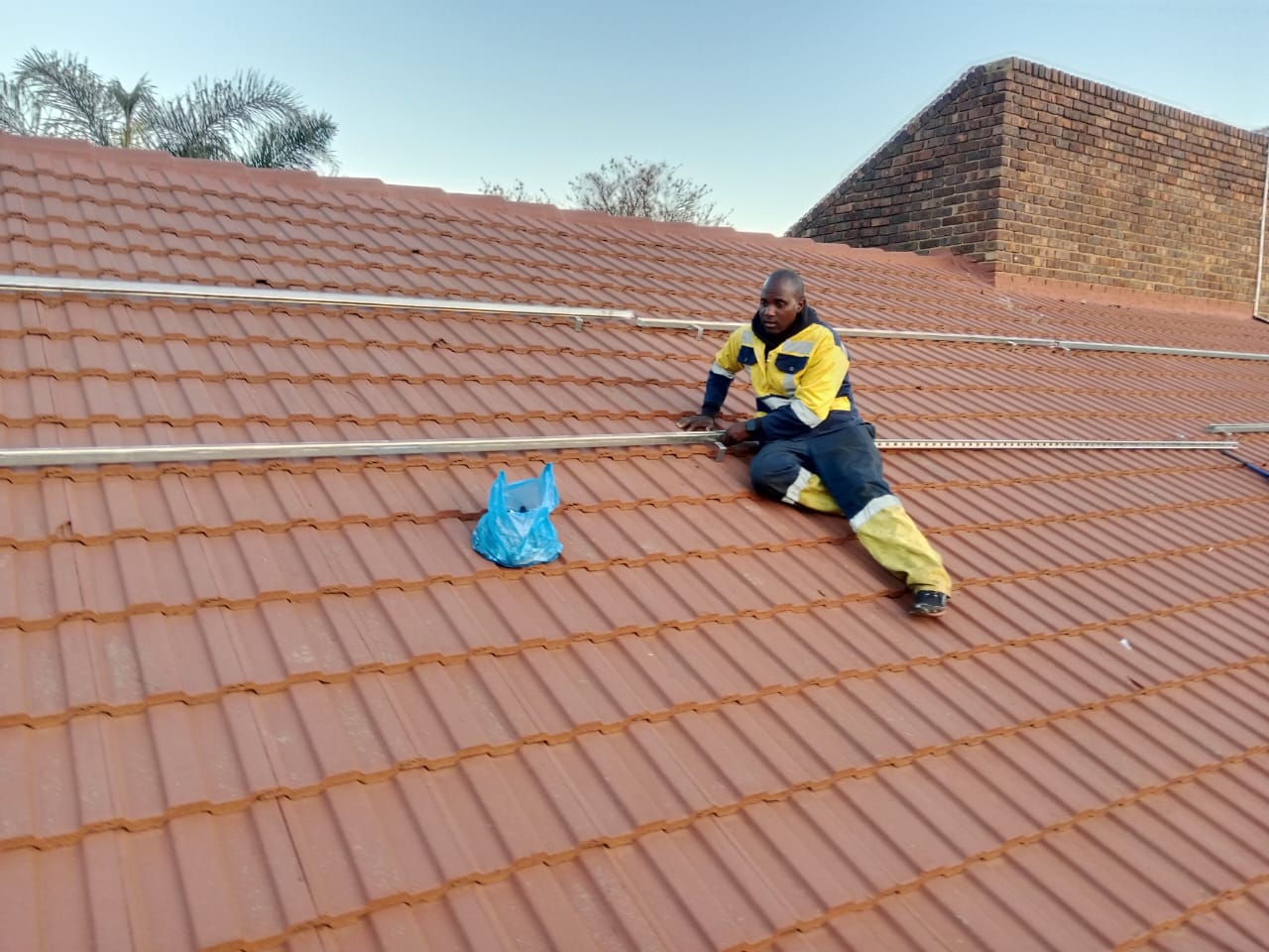 Solar technician working on roof-mounted panel wiring